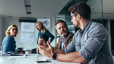 A man is speaking to two women and another man at office