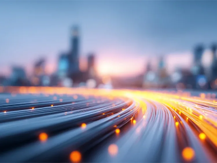 An abstract image of fibre cables heading toward a blurred cityline at a distance