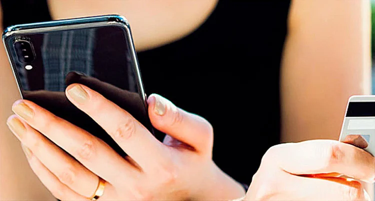 A woman holding a mobile phone in one hand