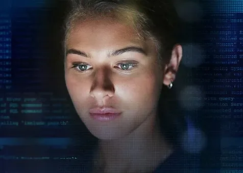 A lady's face against a dark background with codes and scripts on the screen